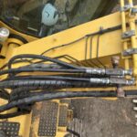 黄色の重機のブーム根元ホース