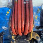 ブルーシートの上にオレンジ色のたくさんのホース