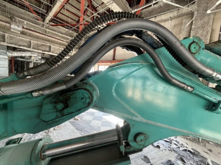 水色の重機に複数のホース