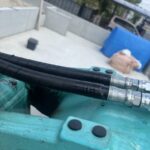 水色の重機に２本のホース