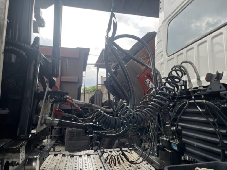 白い重機に複数のホース