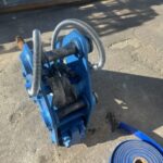 地面に置かれた青い重機とホース