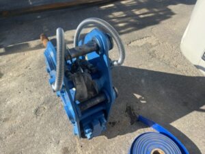 地面に置かれた青い重機とホース