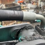 水色の重機に繋がっている太いホース