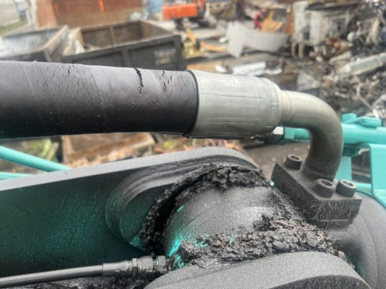 水色の重機に繋がっている太いホース