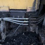 黄色い重機と新品のホース