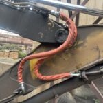 黄色い重機と新品のホース